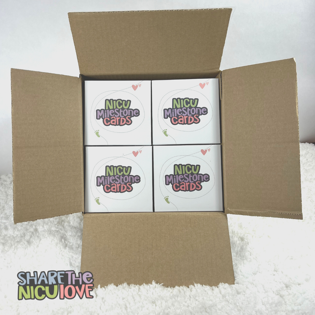 One case of NICU Milestone Cards with 20 decks of cards stacked inside the open box, with the "Share the NICU Love" discount NICU giving bulk purchase logo overlaid
