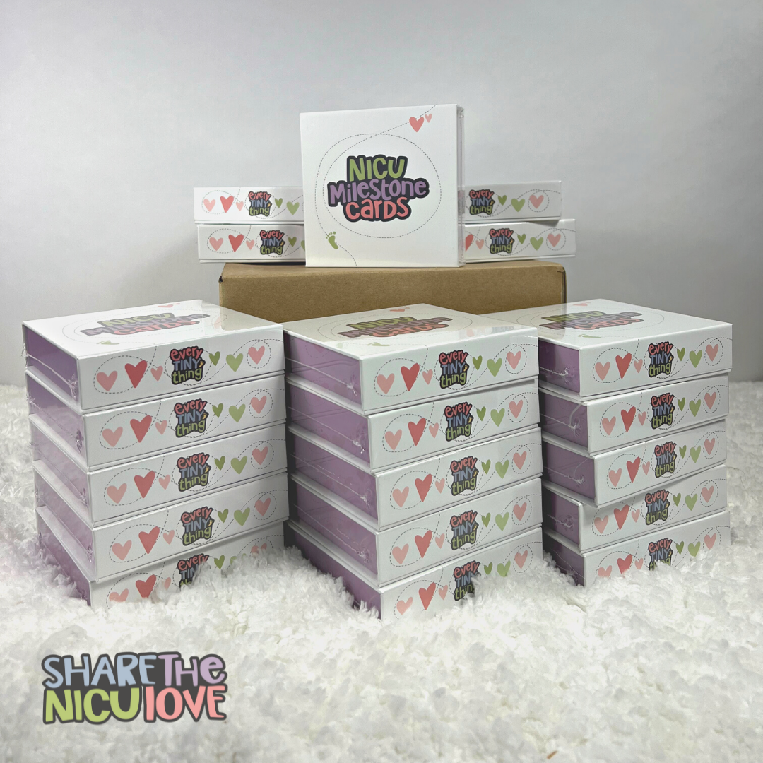 One case of NICU Milestone Cards with 20 decks of cards stacked outside and on top of case, with the "Share the NICU Love" discount NICU giving bulk purchase logo overlaid